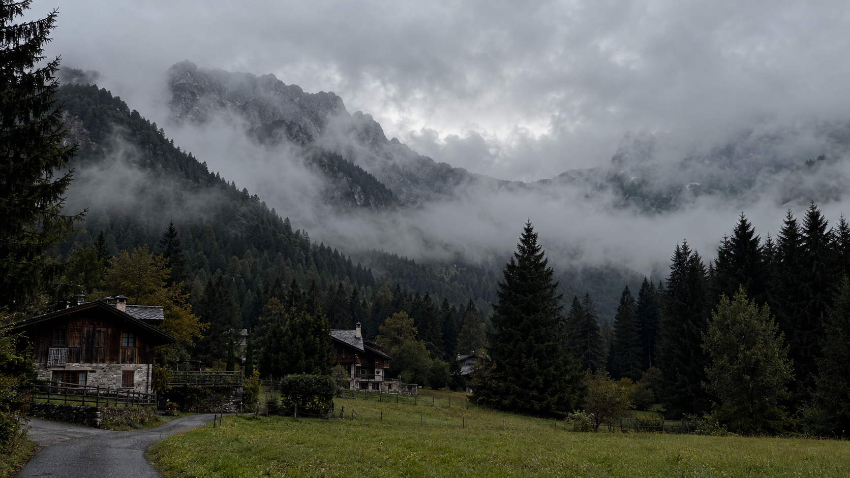 Chalet de montagne dans la brume, vallée boisée