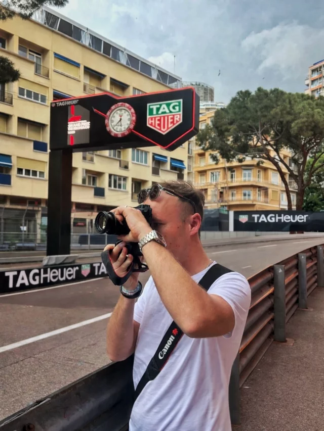 Tournage en bord de piste au Grand Prix de Monaco, sous le panneau TAG Heuer