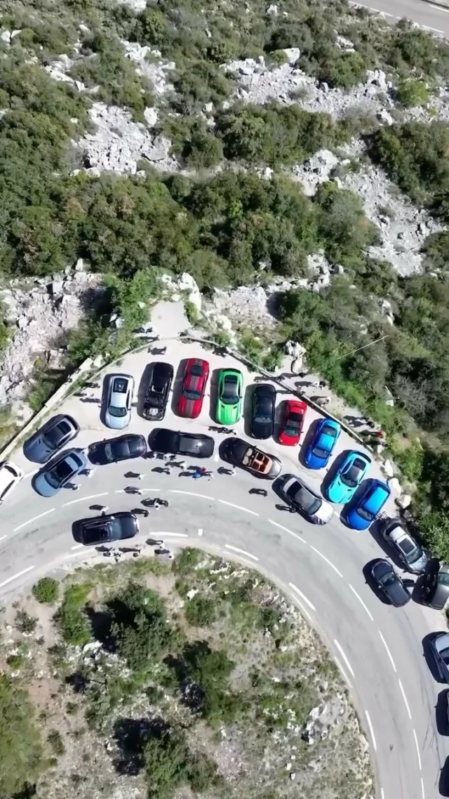 Rassemblement de voitures de sport dans une épingle de l'arrière-pays, vu du drone à la verticale